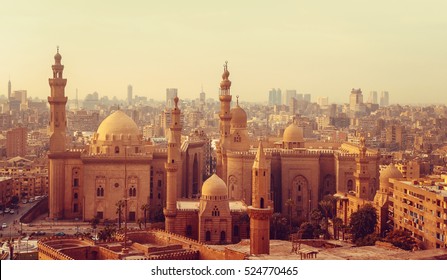 Silhouette of traditional arabic city with minarets. Mosque of Al Rifai and Madrasa of Sultan Hassan - panoramic view of old town in Cairo. Cityscape with landmarks of muslim architecture.