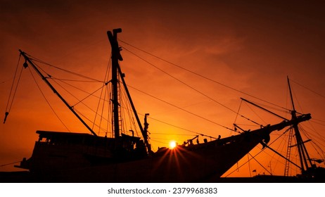 Silhouette of a traditional Pinisi boat at red orange sunset time. - Powered by Shutterstock