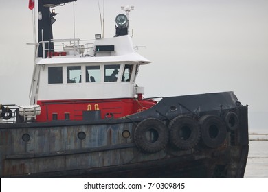 The Silhouette Of A Tug Boat Captain Standing At The Controls In The Bridge Or Wheelhouse. 