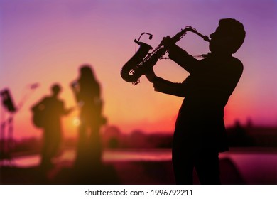Silhouette twilight scene of Saxophone man showing as trio musicians. Background for celebrate party or autumn and summer festival.