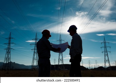 silhouette two engineers standing at electricity station  discussing plan