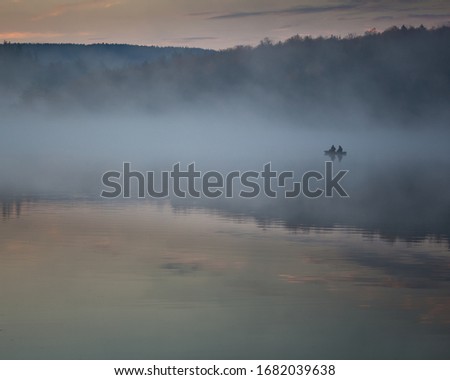 The silhouette of two fishermen on a boat at Spruce Knob Lake in the Monongahela National Forest in Randolph County, West Virginia