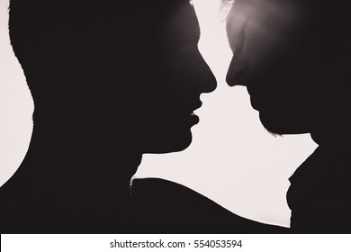 Silhouette of two men  about to kiss