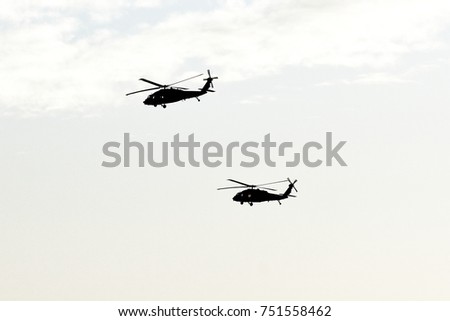 Silhouette of two military transport helicopters in the clear sky above Israel and Gaza Strip.