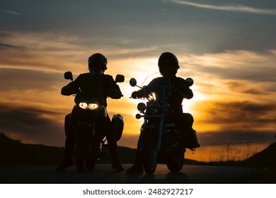 Silhouette of two motorcycle riders on the road with sunset light background. - Powered by Shutterstock