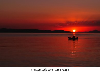Silhouette of two people in the boat on the adriatic sea at sunset. Podgora, Croatia