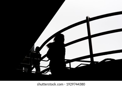 A Silhouette Of Two People Going Down The Stairs