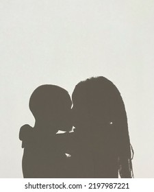 Silhouette Of Two People Kissing. 