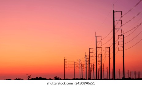 Silhouette two rows of electric poles with cable lines on curve country road against colorful orange sunset sky background after sundown - Powered by Shutterstock