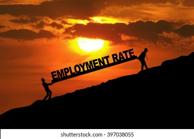 Silhouette Of Two Workers Carrying An Employment Rate Text On The Hill At Sunset Time