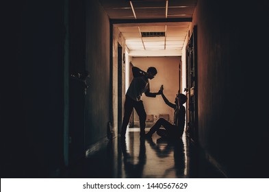 The silhouette of two young men conflict fighting with each other in  the old condo