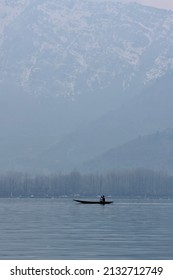 A silhouette of an unidentified man rowing a Shikara(Shikhara) boat on the Dal Lake on a winter morning at Srinagar, Jammu and Kashmir.
