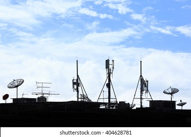 Silhouette Various Communication Devices On Rooftop; Cell Site, Satellite Receiver, TV Antenna