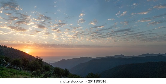 silhouette view from top of mountains at sunrise with cloudy sky in gilan province, iran.