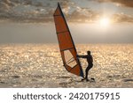 Silhouette water sportsman under play windsurfing is summer sport activity concept with sun sky background. 
