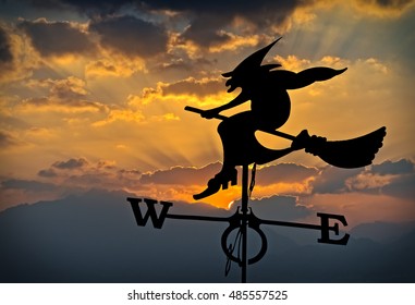 Silhouette of weather vane with witch flying on broomstick  