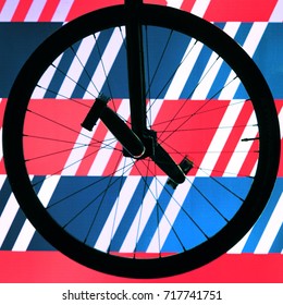 The silhouette of the wheel of a racing unicycle on a radiant background of red, blue and white stripes - Shutterstock ID 717741751