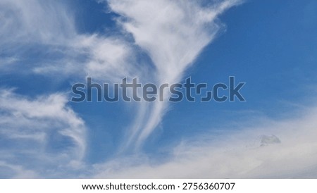 silhouette of white clouds in the shape of a wind vortex