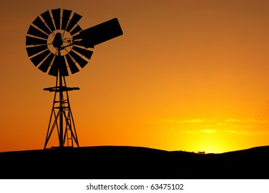 Silhouette of a windmill on a rural farm