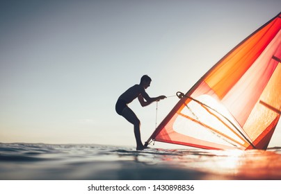 Silhouette of windsurfer uplift windsurf board sail. Windsurfing, sailing, surfing, water sports