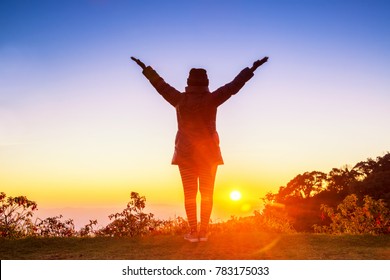 Silhouette Of Woman Arms Up Outstretched For Praying With Sunbeam On Hill. Christian Praise On Hill At Sunset.