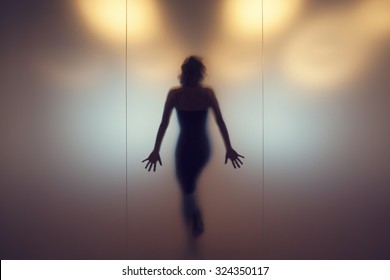 Silhouette Of A Woman Behind A Glass Wall.