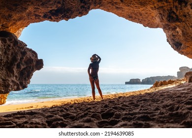 Silhouette of a woman in the cave on the beach in the Algarve, Praia da Coelha, Albufeira. Portugal - Powered by Shutterstock