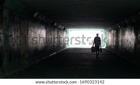 Silhouette of woman in dark underpass. Danger of loneliness and insecurity in city