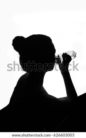 Silhouette of woman drinking bottled water. Isolated on white. Silhouette of a girl drinking water.