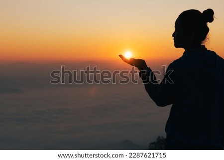 Silhouette of woman hand praying spirituality and religion,  Woman raising his hands in worship. Christian Religion concept background.