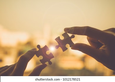 Silhouette Woman hands connecting couple puzzle piece against sunrise effect, businesswoman holding jigsaw with sunset background. Business solutions, target, success, goals and strategy concepts - Shutterstock ID 1012178521