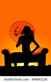 A Silhouette Of A Woman In Her Dress Sitting On A Couch With A See Through Umbrella.