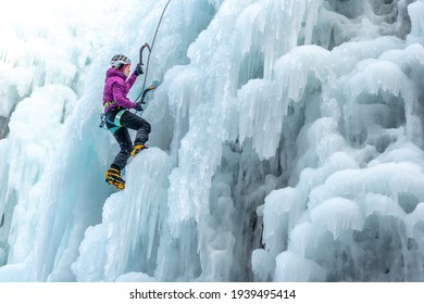 Silhouette of a woman with ice climbing equipment, axe and climbing rope, hiking at a frozen waterfall - Powered by Shutterstock