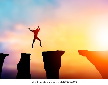 Silhouette woman to jump over obstacles over precipice between rocky mountains A Step to success at background sunset pastel.