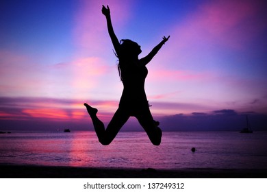 Silhouette Of A Woman Jumping On A Beach