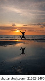Silhouette of Woman Jumping on Beach at Sunset