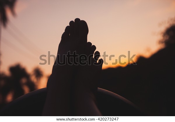Silhouette of woman\
legs,relaxing at summer sunset,sunset palm trees background.Girl\
relaxing at car of her car trip.Road trip playlist,car hacks,USA\
american trip,discover America,Florida,travel\
tips