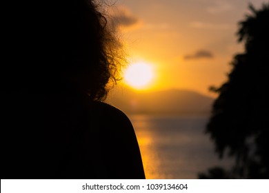 Silhouette Woman Looking To Sunset On Island With Overexposed Sun