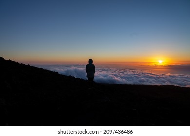 Silhouette Of A Woman Looking At The Sunset, Standing Above The Clouds