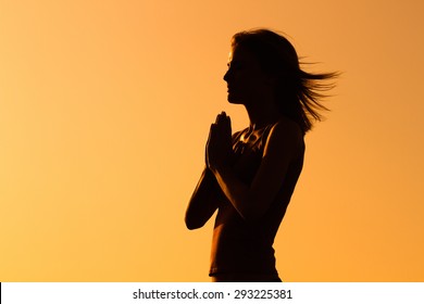La silueta de una mujer meditando.