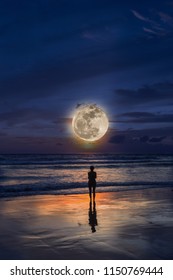 Silhouette Of Woman At Moon Light On The Beach