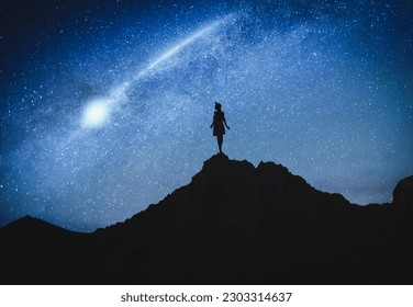 Silhouette of woman in mountains under starry sky at night - Shutterstock ID 2303314637