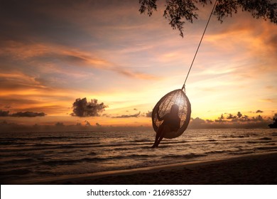 Silhouette Woman On A Beach Swing