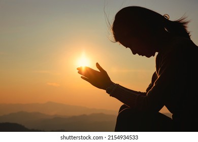 Silhouette woman on sunset background. Woman raising his hands in worship. Christian Religion concept background. - Shutterstock ID 2154934533
