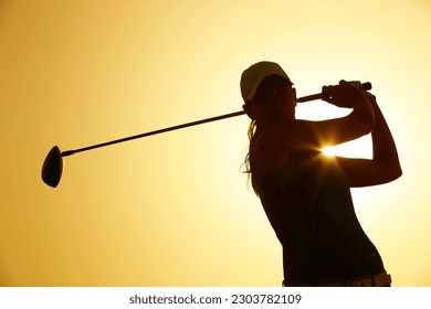 Silhouette of woman playing golf on course - Powered by Shutterstock