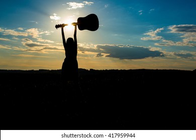 Silhouette Woman Playing Guitar In The Sunset