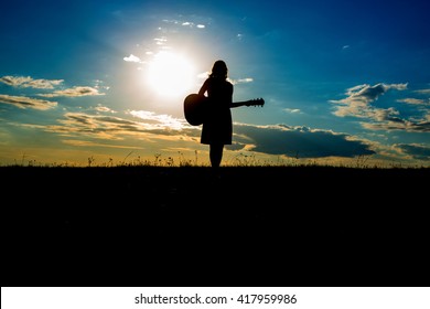 Silhouette Woman Playing Guitar In The Sunset