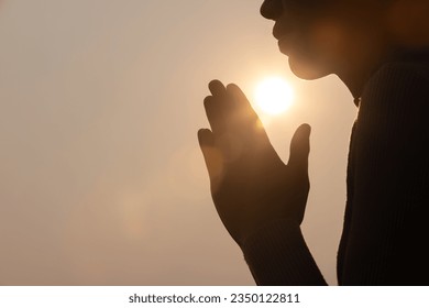 Silhouette of woman prayer position, Praying hands with faith in religion and belief in God on dark background. Power of hope or love and devotion. Namaste or Namaskar hands gesture.