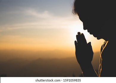 silhouette of a woman  Praying hands with faith in religion and belief in God On the morning sunrise background.  Namaste or Namaskar hands gesture, Pay respect, Prayer position.