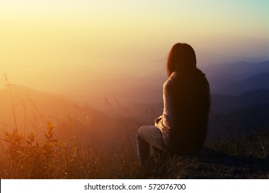 silhouette woman sitting on mountain in morning and vintage filter